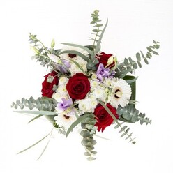 This bouquet, reflecting the artistic flair of a seasoned Pimlico florist, is a masterclass in balance and subtlety. The arrangement spotlights velvety red roses, their spiraled forms rich with feeling and timelessness, perfectly contrasted by the crisp, white gerbera daisies whose petals seem to radiate serenity from their dark, expressive centers. Accents of lisianthus, painted in gentle shades of lilac and lavender, meander throughout, some blossoms half-open, carrying a hopeful energy akin to new spring blooms in Lupus Street gardens. The composition is elevated by a flourishing display of eucalyptus - their silvery-green, circular leaves rising above, diffusing both aromatic freshness and visual movement with every shift of light. Supporting this central display are clusters of delicate white filler flowers, which add a whisper of softness, tinting the bouquet with a perpetual hint of Pimlico's quiet sophistication. Around the foundation, thick, dark green leaves are wrapped with intention, providing an elegant structural frame that complements the clear glass vase and its tangle of fresh, submerged stems. It is an arrangement that invites hands to explore textures, bringing to mind the sensation of strolling through a local flower market, the fragrance a layered weave of rose, greenery, and spring air. Designed to grace both grand celebrations and heartfelt gestures, this bouquet's contemporary yet classic beauty is a reflection of life in Pimlico: inviting, creative, and always thoughtfully curated.